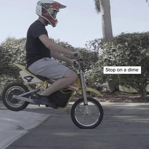 Person riding yellow dirt bike demonstrating use of Front Brake Disc Rotor For Razor MX500 MX650 Electric Dirt Bikes Six And One Quarter Inch Outside Diameter 159mm Six Mounting Holes Heavy Duty Front Rotor For Dirt Rocket Brakes in action.