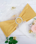 Gold spandex chair sash with circular crystal buckle, front view, wedding banquet decor.