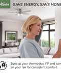 Woman adjusts thermostat with 48 Inch Damp Rated Ceiling Fan No Light With 5 Blades White Finish in living room.