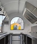 Interior view of Hustle Ready Mobile Catering Trailer With Full Cooking Line And Spacious Serve Window, showcasing stainless steel counter and equipment.
