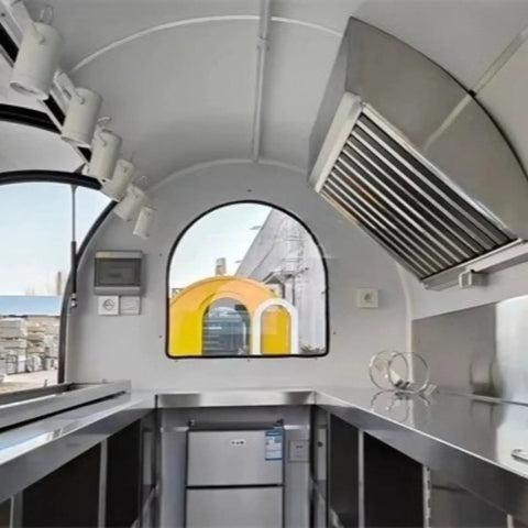 Interior view of Hustle Ready Mobile Catering Trailer With Full Cooking Line And Spacious Serve Window, showcasing stainless steel counter and equipment.