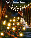 Outdoor Solar Firefly Lights 4 Pack With 32 LEDs Waterproof Pathway Lamps For Yard And Patio Solar Powered Garden Decor That Sways In The Breeze Bright Modern Night Lighting Awesome Gift For Women Moms Friends illuminating a garden path with flower beds at night.