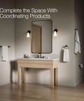 Bathroom scene with Kumin Matte Black Pivot Toilet Paper Holder, beige vanity, and matching fixtures in a modern setting.
