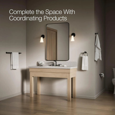 Bathroom scene with Kumin Matte Black Pivot Toilet Paper Holder, beige vanity, and matching fixtures in a modern setting.