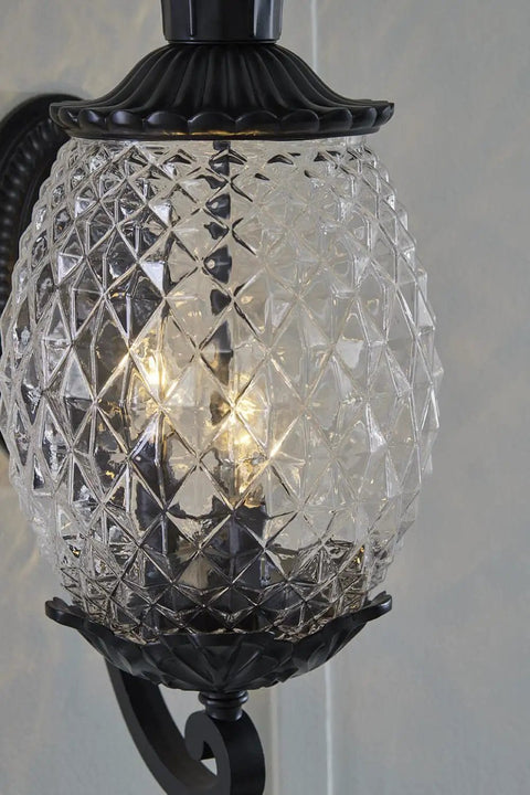 Close-up of a Three Light Outdoor Wall Mount Sconce In Matte Black With Pineapple Cut Glass, showing intricate glass detailing.