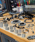 Bike workshop with Five Sets Of Ten Types Bike Bearing Kit With Headset Retainers for crank and caged wheel repairs.