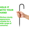 Hand holding a 12 inch black galvanized steel J-shape hook from Heavy Duty Set Of 20 12 Inch Garden Ground Stakes Galvanized Steel J Shape Hooks Rebar Anchors For Tents, Fences, Trampolines, And Outdoor Landscaping Projects And More.
