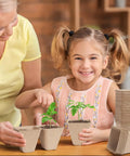 Child and adult using Square Peat Seed Starter Pots, 150 Pack, 3 Inch Biodegradable with Labels for seedlings in home.