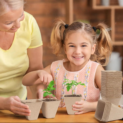 Child and adult using Square Peat Seed Starter Pots, 150 Pack, 3 Inch Biodegradable with Labels for seedlings in home.
