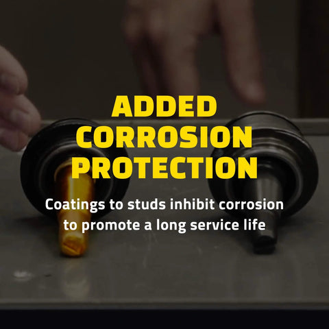 Two suspension control arm studs with corrosion protection coating visible on a table.