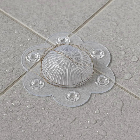 Clear PVC shower drain hair catcher cover with six suction cups, designed to block hair for steady water flow.