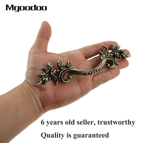 Hand holding Five Piece Antique Bronze Drawer Handle Set 6.61 Inch Vintage Cabinet Pulls for furniture with floral design
