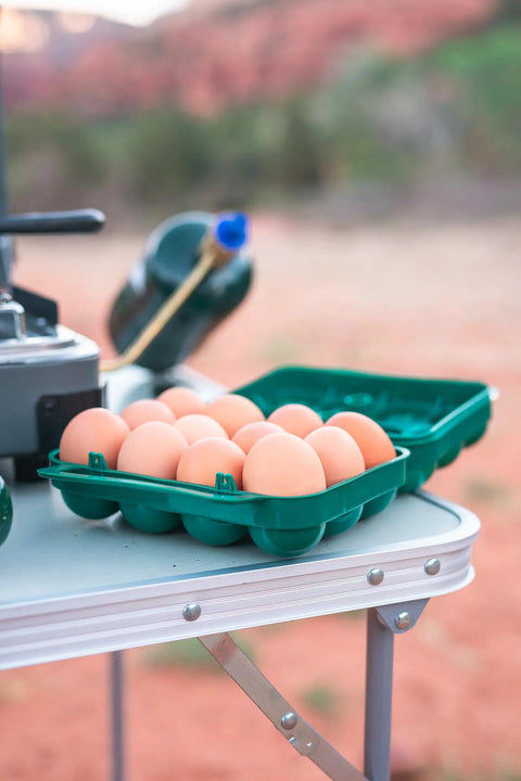 Tough 12-Egg Plastic Carrier With Locking Lid, Molded Handle, And Secure Fit For Camping, Road Trips, And Meal Prep on table