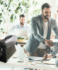 XXL Boss Level Fireproof and Waterproof Document Bag with TSA Lock on office desk with colleagues in background