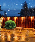 12 Pack Solar Deck Lights Outdoor Waterproof Step Fence Lighting illuminating a wet patio at night with festive decorations