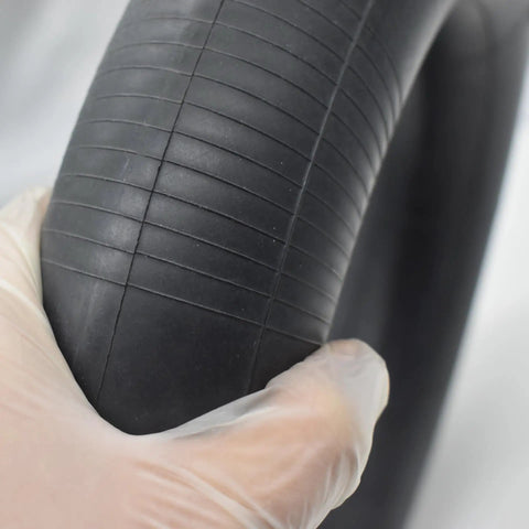 Gloved hand holding Heavy Duty Butyl Rubber Inner Tube For 8 Inch Tires 3.00-8 3.25-8 Dual Wheel Yard Wheelbarrow Garden Cart Replacement 1 Pack With TR87 Bent Valve Stem Built For Tough Outdoor Work And Easy Inflate Ready To Install