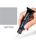 Hand holding tube of Light Gray Tile Repair Filler And Touch Up Paint For Porcelain Tiles And More, Ultra Durable Nanotech Formula