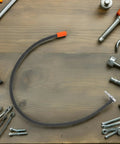 Solid As A Rock Metal High Pressure Tire Inflator Extension Hose Leakproof Design Universal Fitment For Your Car Or Bike To Stay Pressed Up No Drama With Wear Resistance To Handle Any Job Wherever You Are From Garage To Highway, black hose with orange and metal connectors on wood