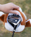 Hand placing a golf driver inside Corgi Driver Headcover Soft Plush Golf Club Cover Brown And White Totally Cute Corgi Design With Realistic Face And Paws Durable Material For Golfers Great Gift For Any Golf Enthusiast