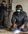 Worker using Automatic Welding Helmet With True Color Lens, Safety Cover, And Air Supply Respirator System in industrial setting.