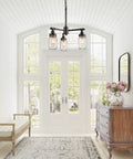 Farmhouse Mason Jar Chandelier Pendant Light For Kitchen Island And Dining Room, Industrial Brushed Dark Metal Frame With Clear Glass Jars, 16.9 Inch Height, Rustic Cottage Farmhouse Lamp For Cozy Vibes hanging in a bright hallway.