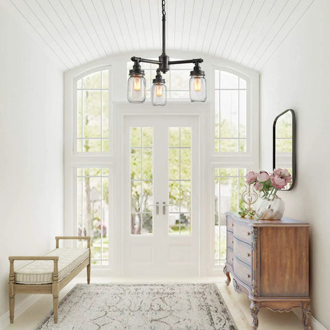 Farmhouse Mason Jar Chandelier Pendant Light For Kitchen Island And Dining Room, Industrial Brushed Dark Metal Frame With Clear Glass Jars, 16.9 Inch Height, Rustic Cottage Farmhouse Lamp For Cozy Vibes hanging in a bright hallway.