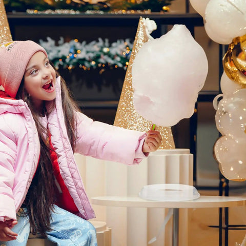 Child holding cotton candy next to cotton candy machine guard cover enclosure for portable mini candy makers white plastic shield