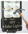 Top Tier Outdoor Solar Flood Light For Yard And Patio Security IP67 Waterproof Motion Detection Dusk To Dawn aviation aluminum build being installed with a hammer.