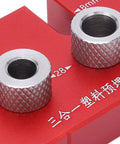 Two metal bushings on a red guide block for the Top Shelf Wood Doweling Jig Drill Kit With Spot On Scaling Ruler And Rugged Aluminum Frame For Hassle Free Furniture Joinery And Cabinet Refinishing Projects Built Damn Tough And Ready For Work Red.