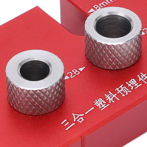 Two metal bushings on a red guide block for the Top Shelf Wood Doweling Jig Drill Kit With Spot On Scaling Ruler And Rugged Aluminum Frame For Hassle Free Furniture Joinery And Cabinet Refinishing Projects Built Damn Tough And Ready For Work Red.