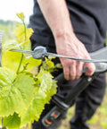 Easy Fencing Wire Joiner Medium Gauge 10 To 13.5 in use on vineyard fence wire by person holding a tool, front view.
