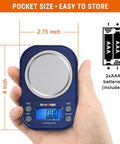 Hand holding blue Pocket Digital Gram Scale 0.01g Precision, 300g Capacity for Jewelry Coffee and Kitchen, showing LCD display.