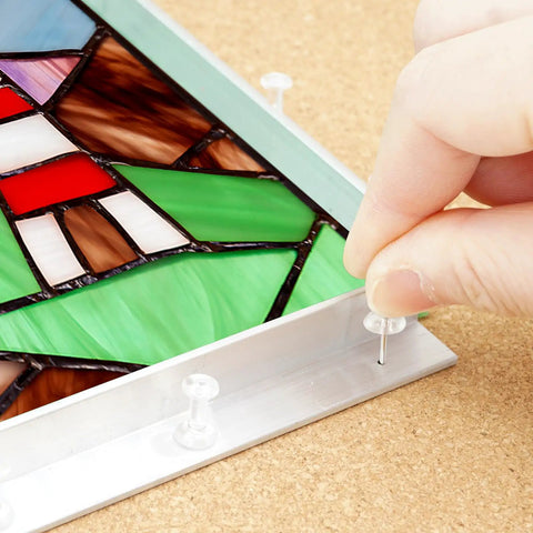 Close-up of Pro Grade Stained Glass Layout Block Kit showing template use with push pins on stained glass design.