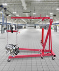 Hoss Strength Folding Engine Hoist With Lever 2 Ton Hydraulic Cherry Picker lifting an engine in a spacious garage setting.
