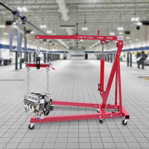 Hoss Strength Folding Engine Hoist With Lever 2 Ton Hydraulic Cherry Picker lifting an engine in a spacious garage setting.