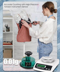 Woman measuring fabric on mannequin with Electronic Fabric GSM Scale With 0-2mm Disc Sampler For Textiles And Nonwoven Fabrics Digital Weight Balance 1000g Capacity 0.01g Readout Includes Sampler 110V Scale visible.