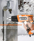 Hot Air Gun With 9 Temp Dial And 3 Fan Speeds for thawing frozen pipes in winter setting, person using heat tool outdoors