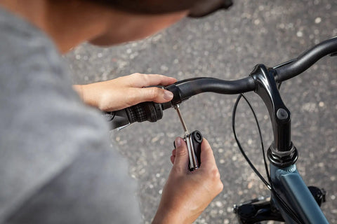 Person using 18 Function Bike Repair Tool Kit With Wrenches, Screwdrivers And Tire Levers, Ultra Portable Go To Multi Tool for fixes
