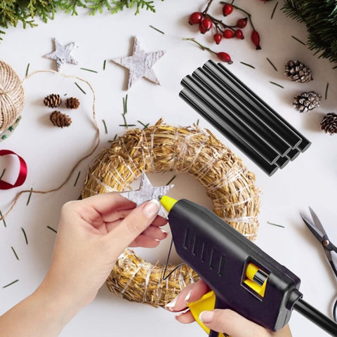 Person using glue gun with Clear Hot Glue Sticks 36 Pack Bulk Full Size 3.93 Inch By 0.43 Inch for DIY crafts on wreath