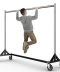 Heavy Duty Rolling Garment Rack With 500LBS Capacity Adjustable Chrome Clothes Rack on wheels with person demonstrating strength.