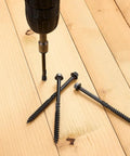 Heavy Hitter Deck Screws 14 X 4 Inch Hex Head Wood Structural Fasteners in use with a power drill on wooden planks.