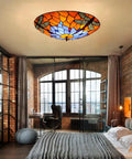 Dragonfly 3 Light Flush Mount Ceiling Light With Orange Stained Glass Shade 16 Inch Fixture in cozy living room