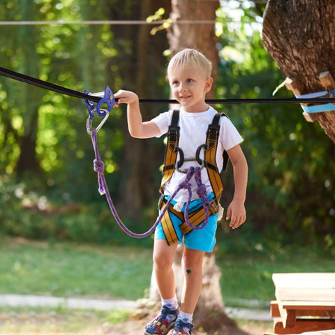 Child using Heavy Duty Trolley Kit With Slackline Pulleys For Backyard Fun, secured on a slackline in a backyard setting
