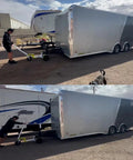 Person using Monster Tug Off-Road Trailer Dolly to maneuver a large silver trailer on gravel surface.