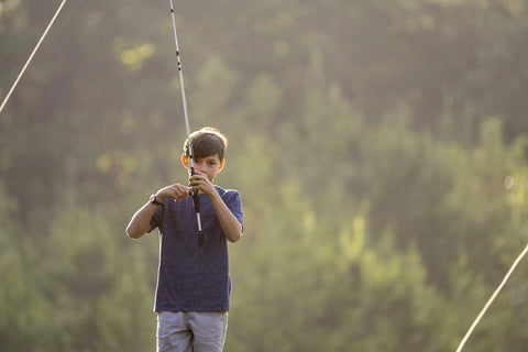 Boy using Youth Spincast Fishing Rod And Reel Ike Dude 5 Foot 6 Inch 2 Piece Easy To Learn Kid Friendly Combo outdoors