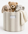 Slick Striped Woven Storage Basket With Beige And White Accents handy side handles holding stuffed animals and a blanket.