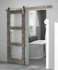 Brass Sliding Barn Door Hardware Kit In Brushed Gold Finish installed on wooden door in bathroom, carbon steel track visible