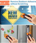 All In One Blade Scraper With 50 Blades For Glass Windows And Cooktops Includes Plastic Safe Blade And Metal Heavy Duty Blade Decal Remover Tool Orange in use removing decals from glass and paint.
