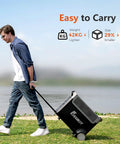 Man pulling a portable 3600W power station with 3840Wh LiFePO4 battery on grass beside a lake, showcasing easy portability.
