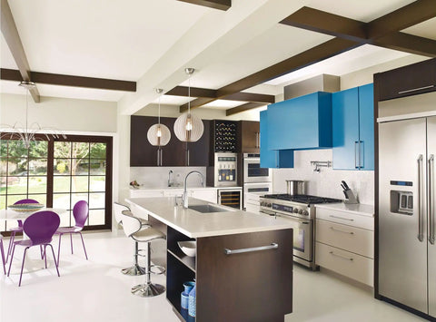 Modern kitchen with dining area, island, stainless steel appliances, and purple chairs around the table.